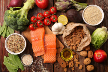 Verschiedene Nahrungsmittel in einem Foto von oben (Lachs, Nüsse, Reis, Tomaten, Avocado ...)